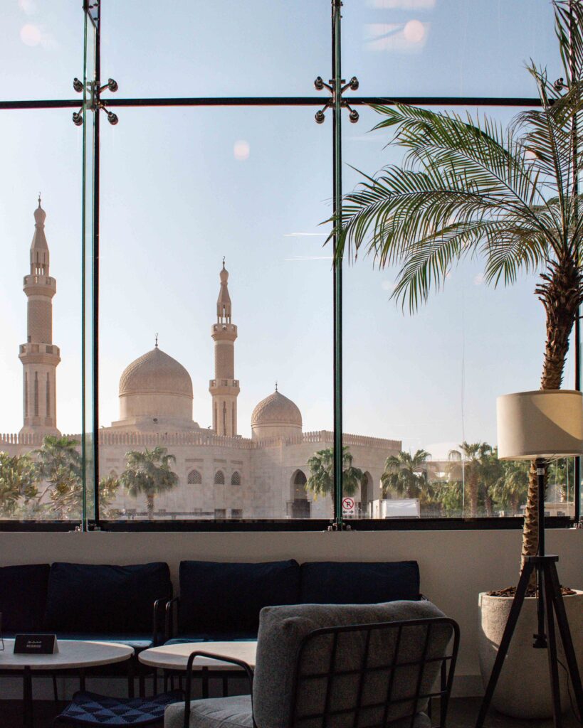 View of mosque minarets through window of Mirzam chocolate shop, Dubai